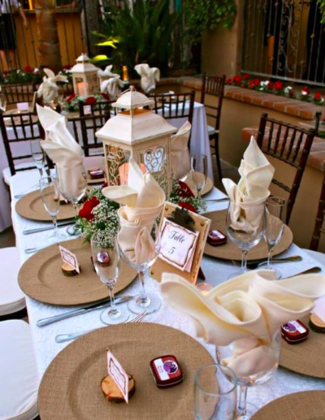 Formal outdoor banquet setup with lanterns and floral centerpieces